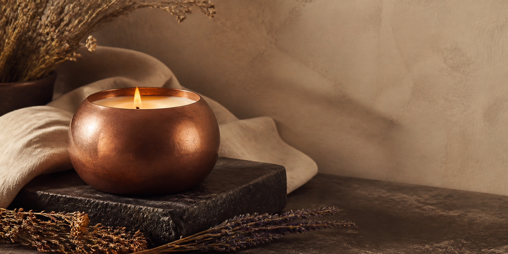Copper aromatherapy candle burning beside botanicals